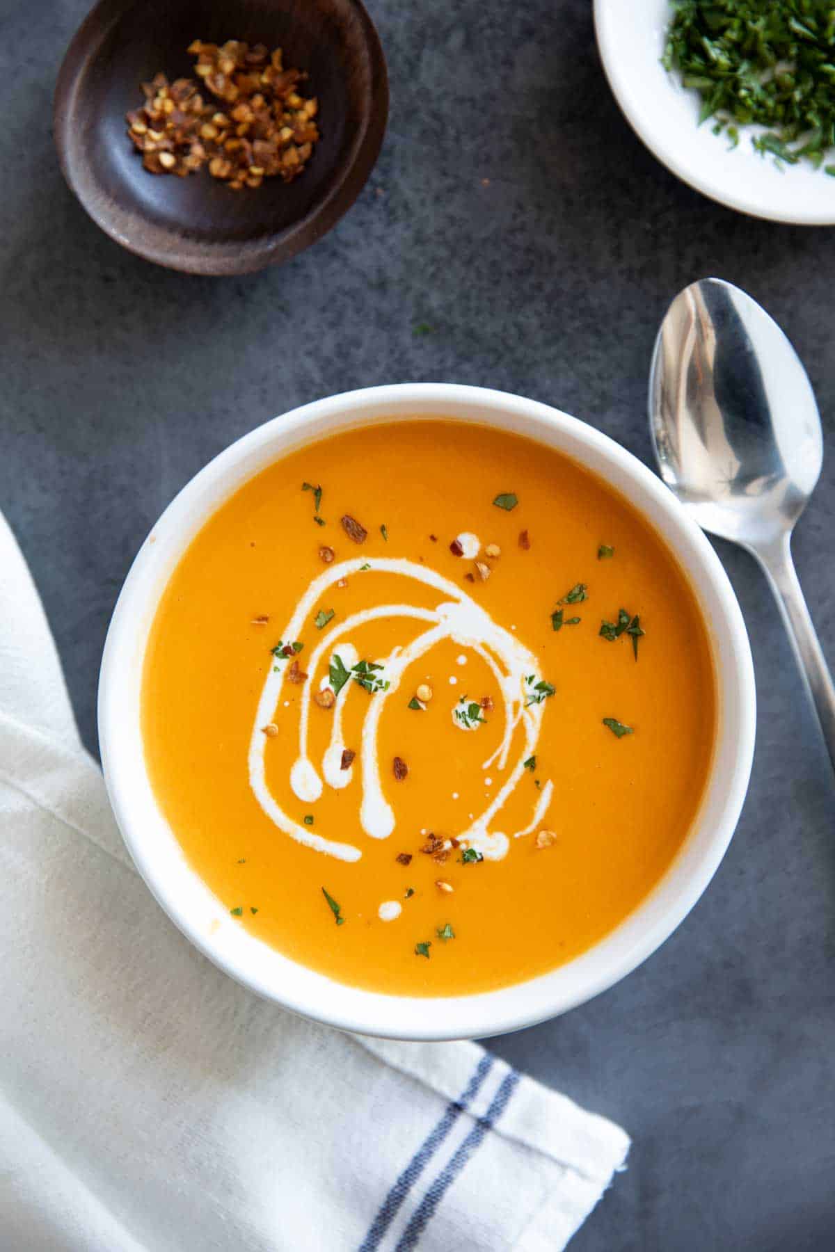 Bowl of sweet potato soup drizzled with cream.