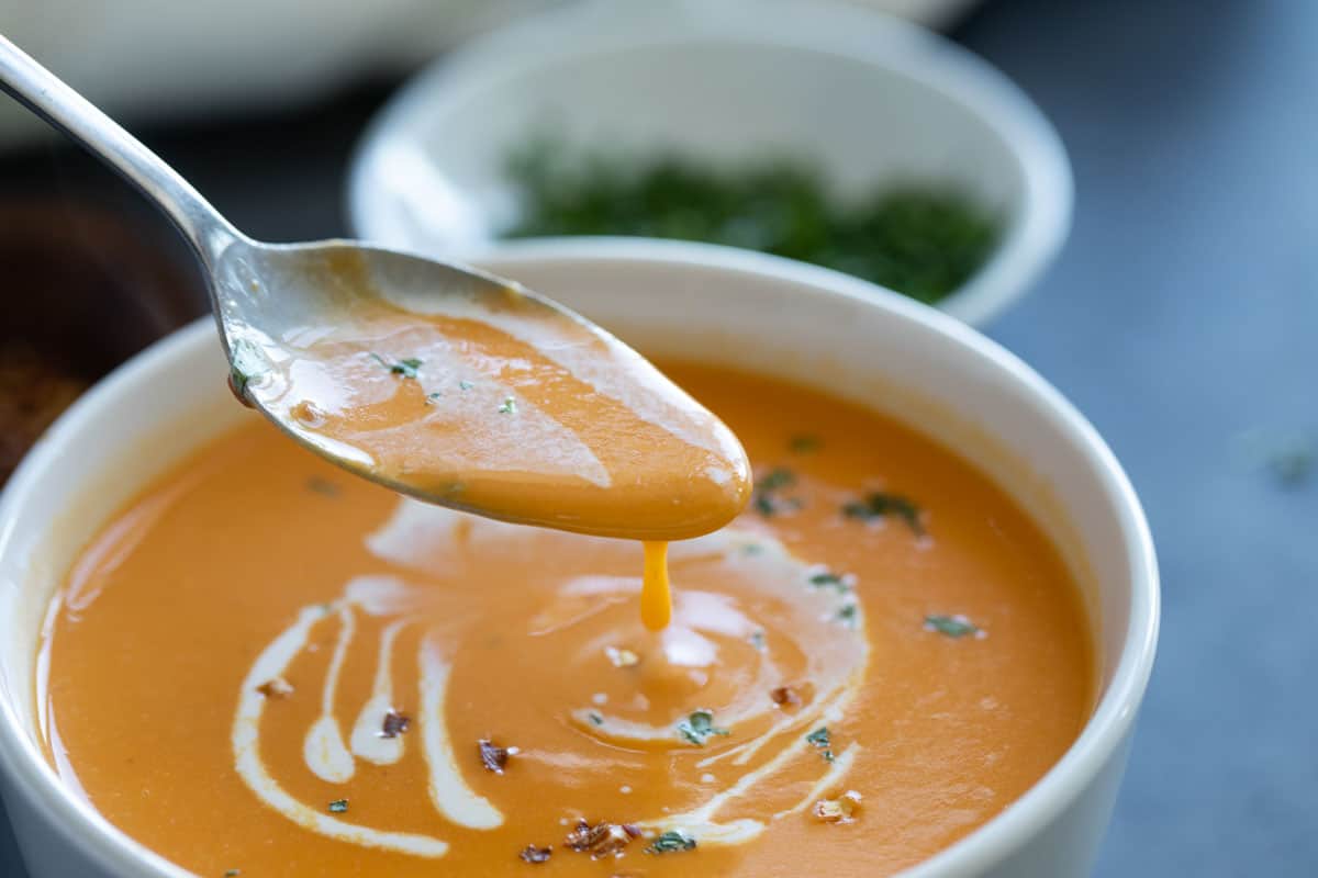 Bowl of sweet potato soup with a spoon.