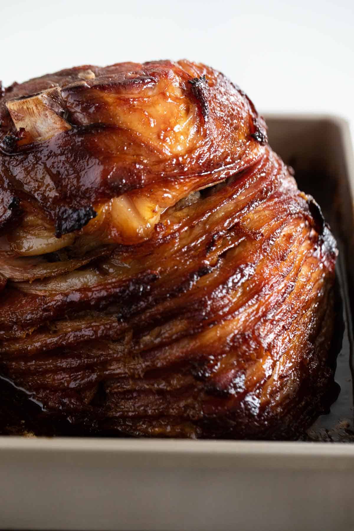 Full honey glazed ham in a pan.