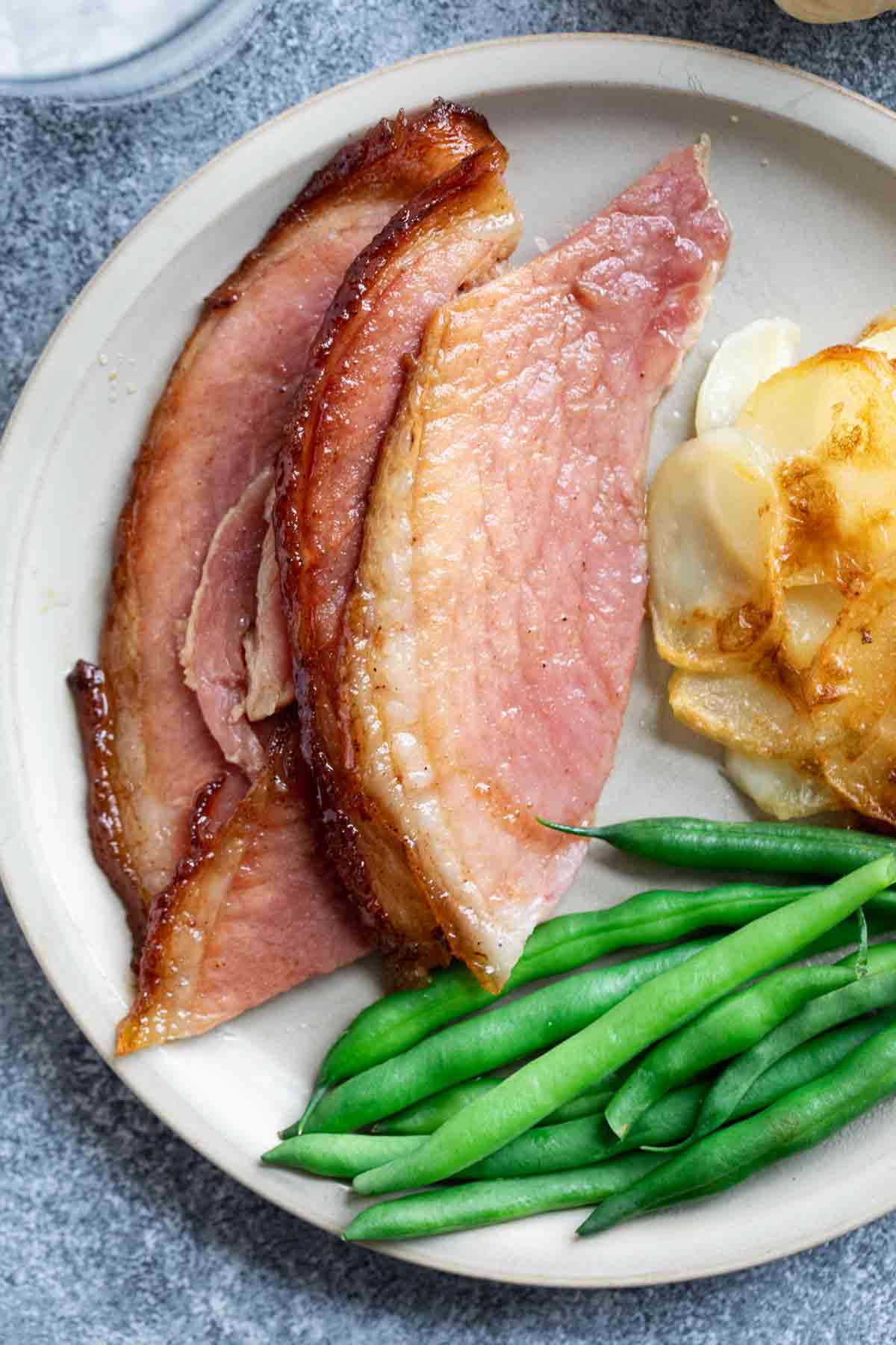 Honey Glazed Ham on a plate with green beans.