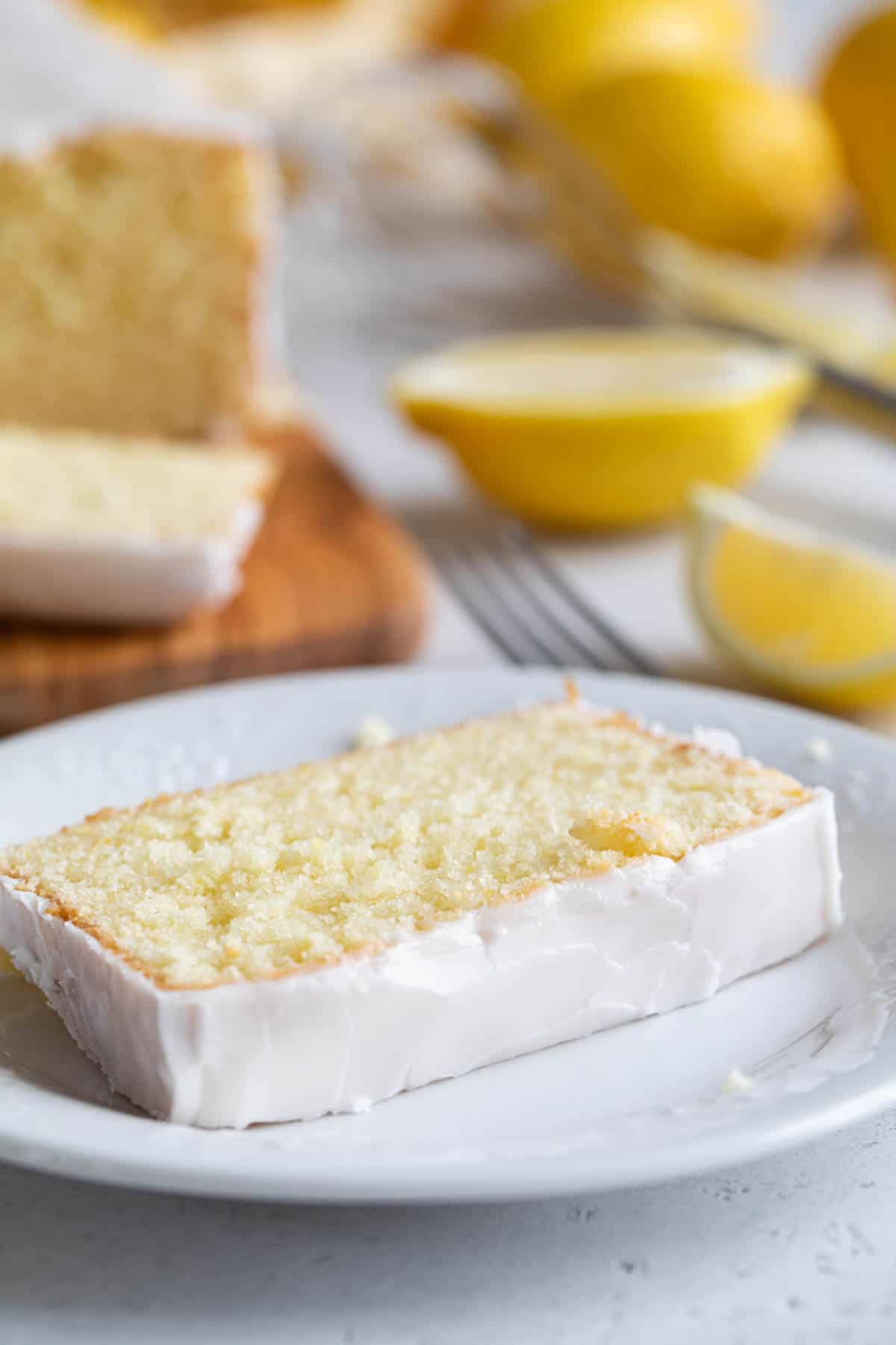 Slice of iced Lemon Loaf on a plate.