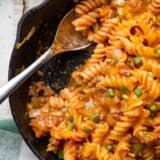 Sloppy joe pasta in a cast iron skillet with a spoon.