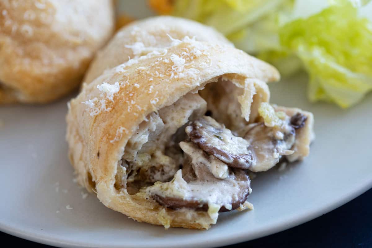 Chicken crescent roll showing the inside with chicken and mushrooms.