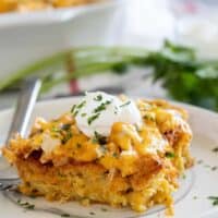 Slice of chicken tamale casserole topped with sour cream.