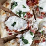 Clam pizza with bacon, mozzarella, and basil.