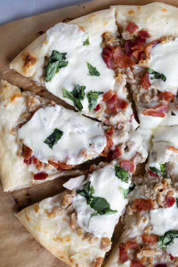 Clam pizza with bacon, mozzarella, and basil.