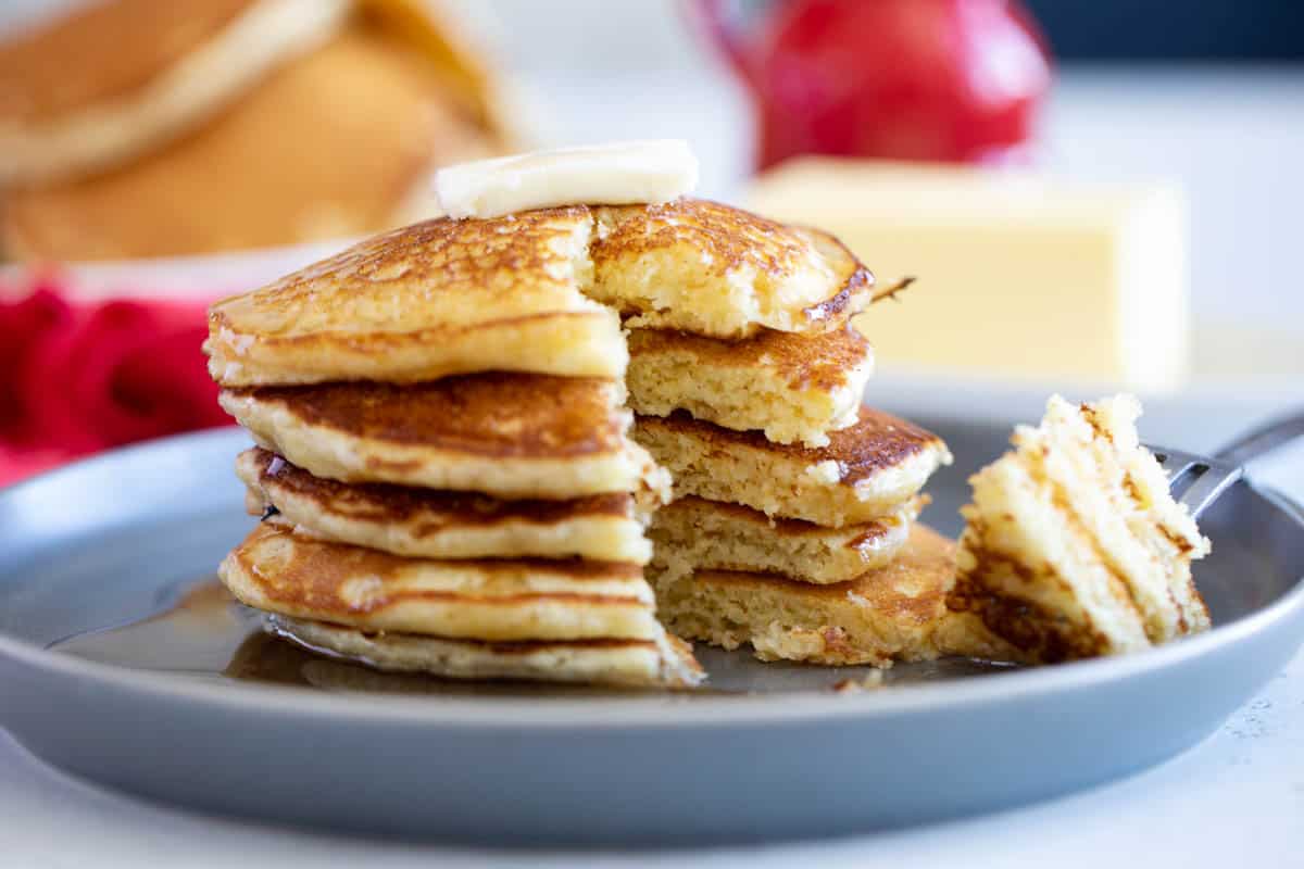 Stack of cornmeal pancakes with a bite taken from them.