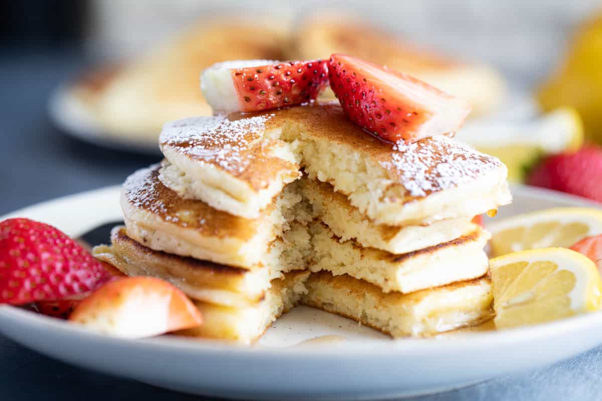 Stack of Lemon Ricotta Pancakes with a bite taken from them.