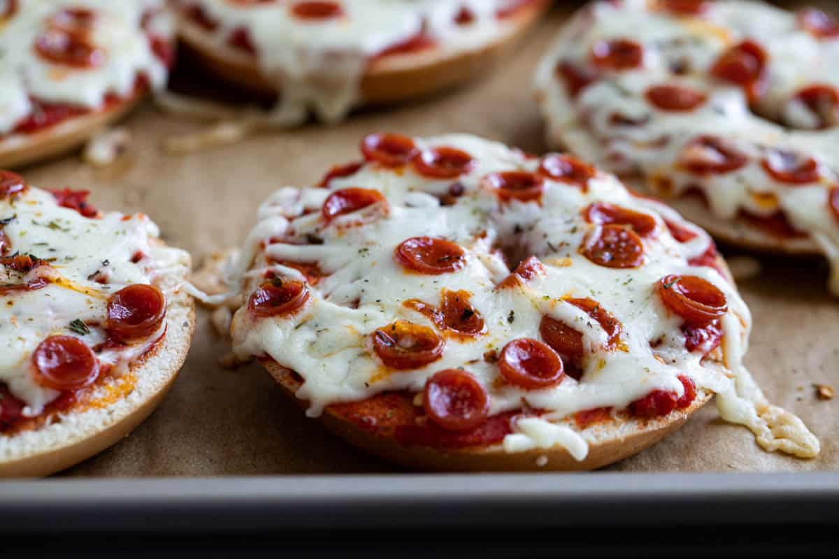 Pizza bagels on a baking sheet.