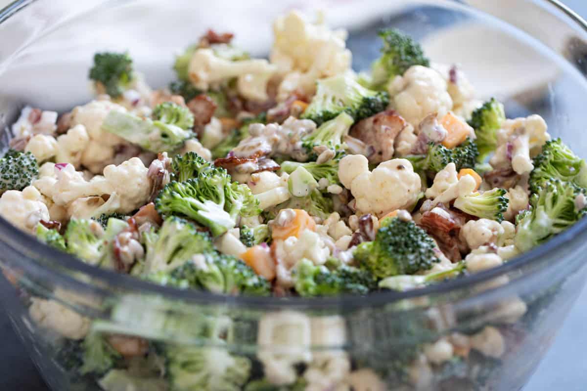 Broccoli Cauliflower Salad with bacon and cheese in a glass bowl.
