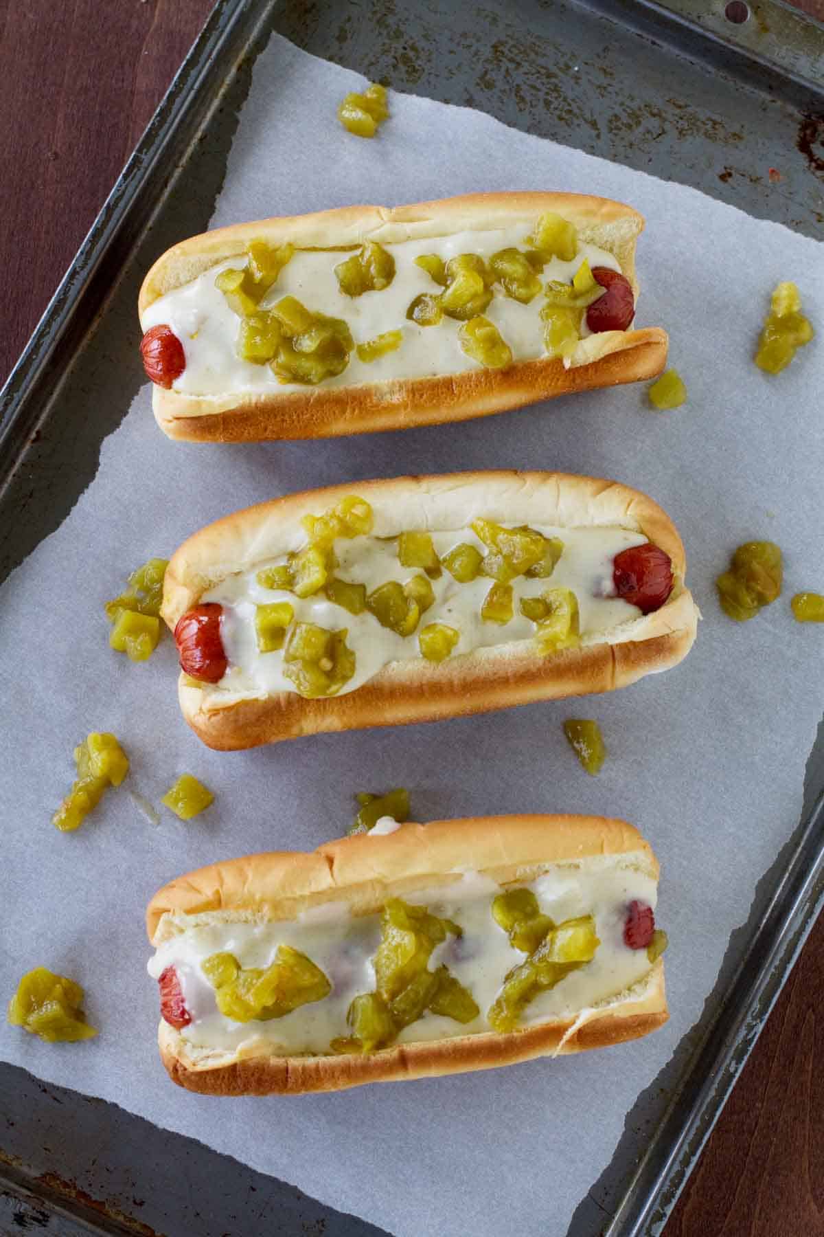 Green Chile Hot Dogs on parchment paper on a baking sheet.