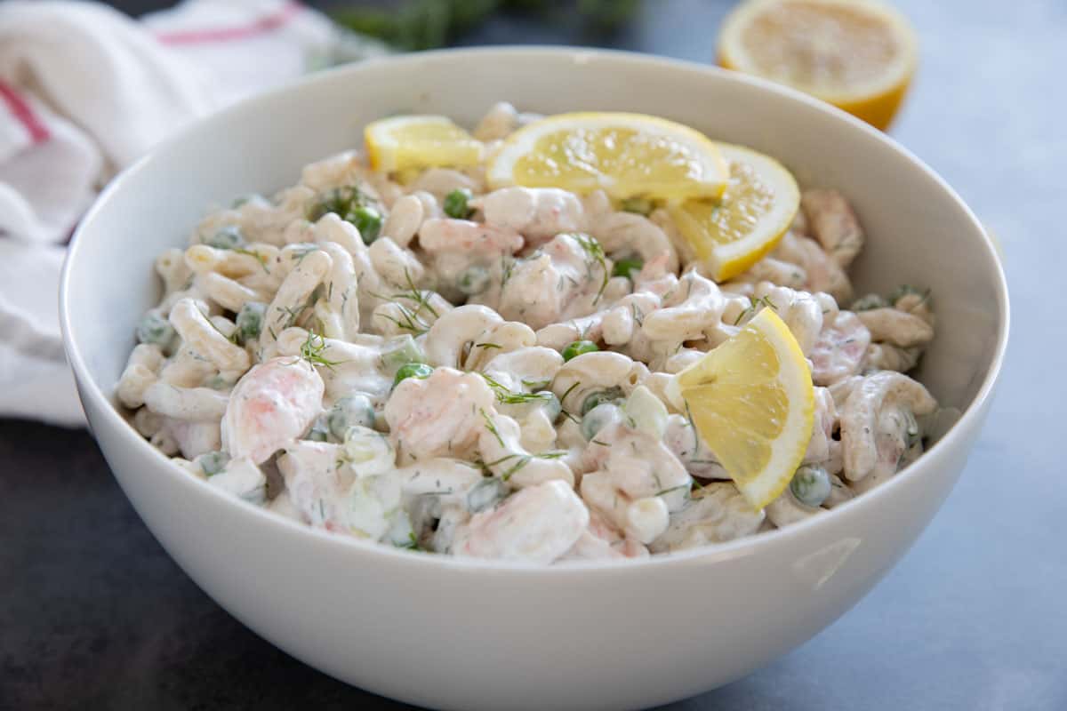 Bowl filled with shrimp pasta salad, topped with fresh dill.