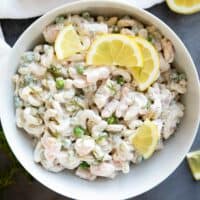 Bowl filled with Shrimp Pasta Salad topped with lemons and dill.