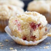 Strawberry Muffin with crumb topping with a bite taken from it.