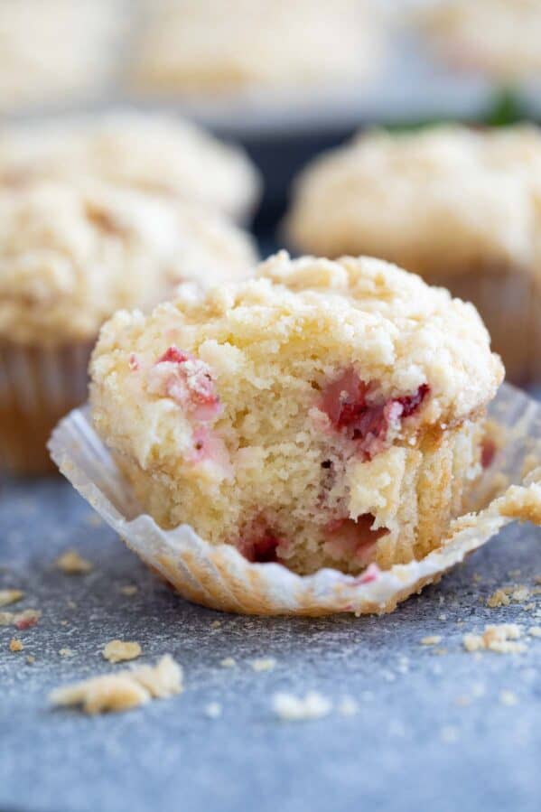 Strawberry Muffin with crumb topping with a bite taken from it.