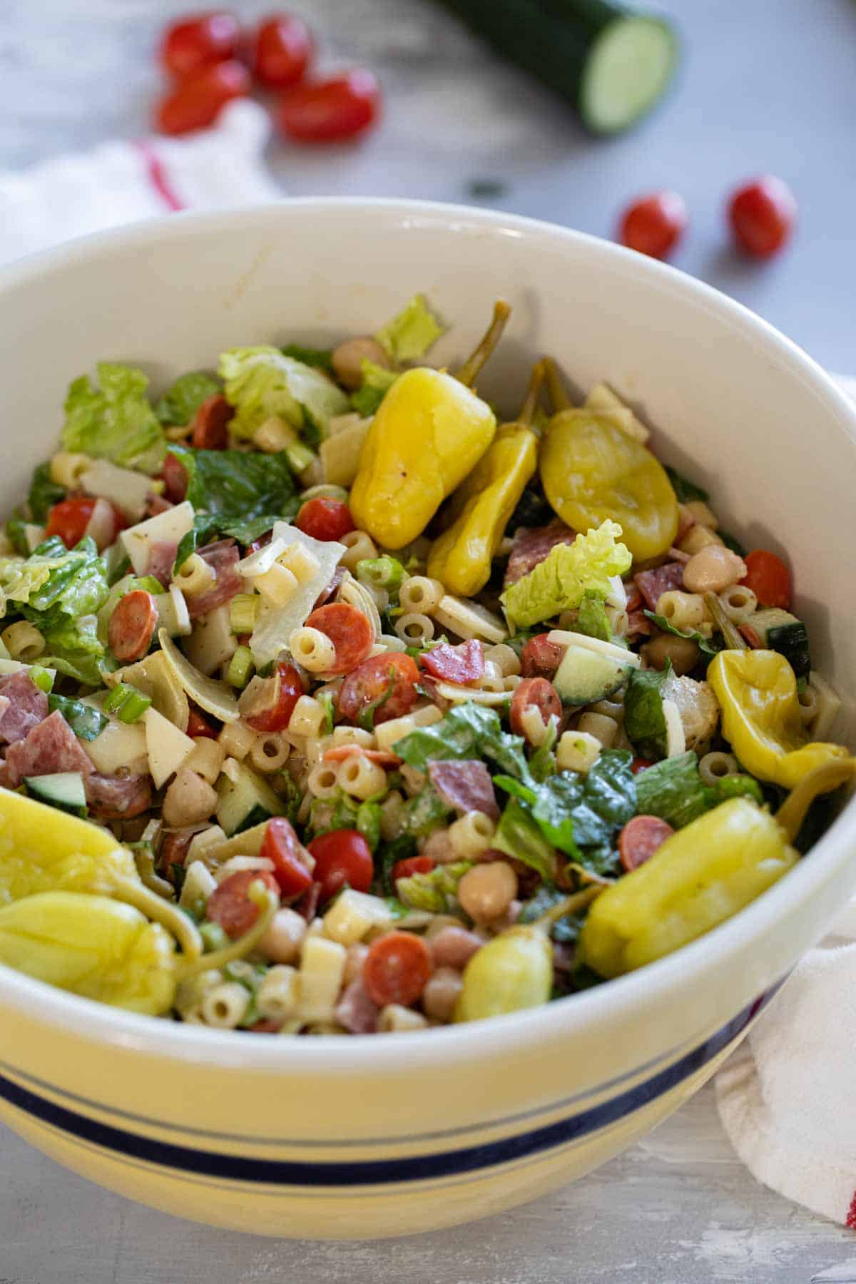 Italian Chopped Salad topped with pepperoncini peppers in a large bowl.