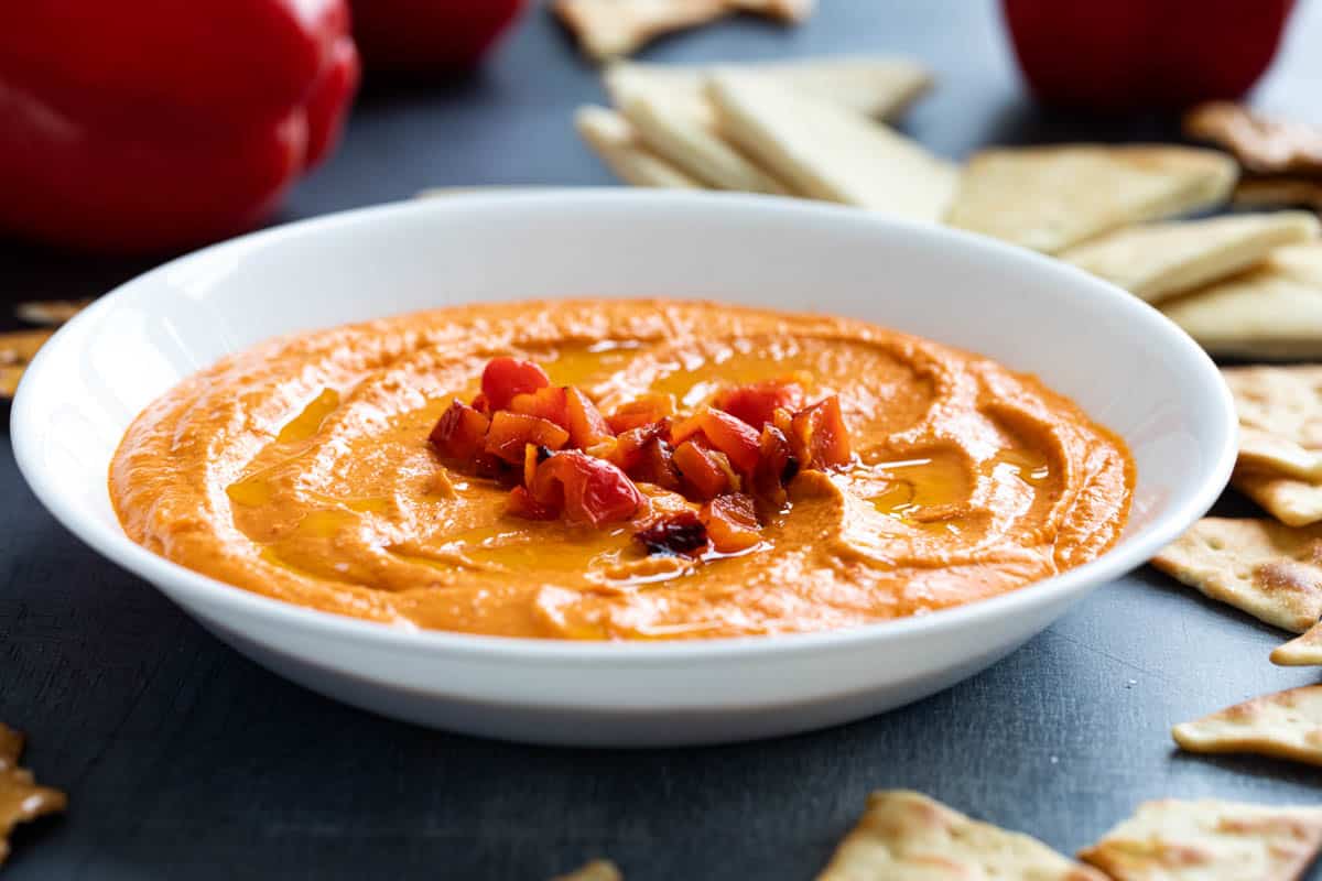 Homemade roasted red pepper hummus topped with chunks of roasted red peppers.