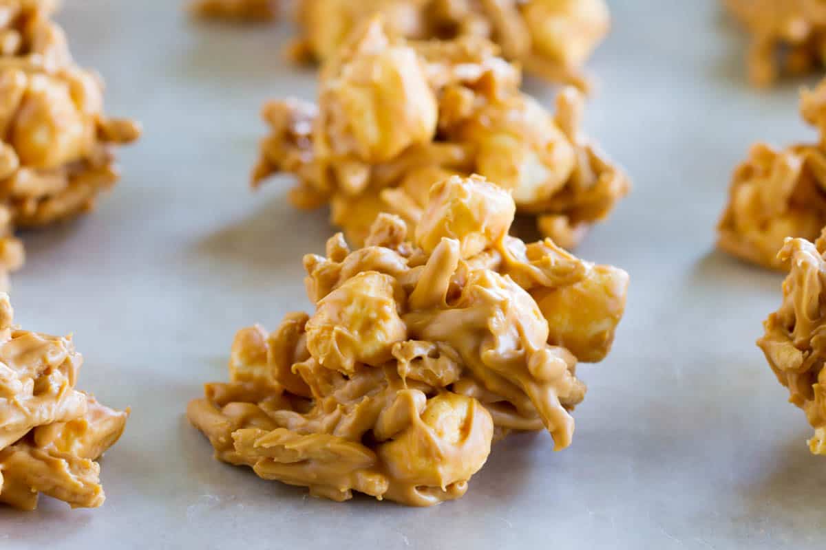 Only 4 ingredients and a few minutes prep, these Haystack Cookies take you back to childhood. Filled with butterscotch and peanut butter, cookies don't get easier than this! Haystack cookies cooling on wax paper.