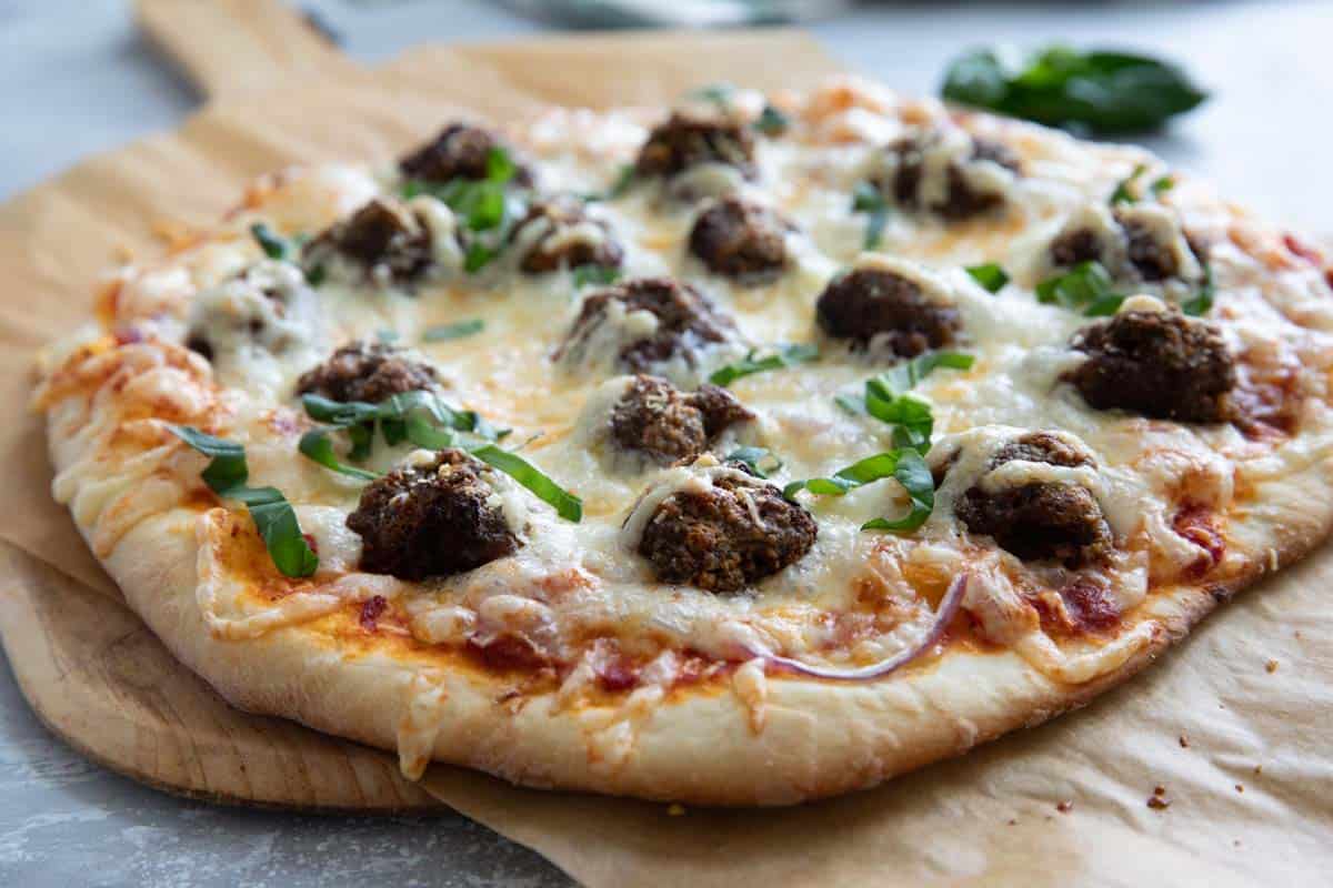 Full meatball pizza - pizza topped with meatballs, sauce, and cheese.