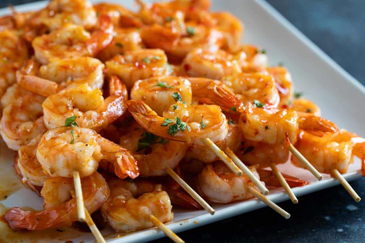 Chili Honey Garlic Shrimp Kabobs stacked on a serving plate.
