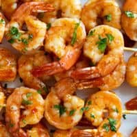 Chili Honey Garlic Shrimp Kabobs stacked on a plate.