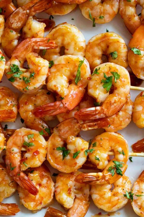 Chili Honey Garlic Shrimp Kabobs stacked on a plate.