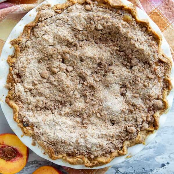 Full sour cream peach pie with a streusel topping.