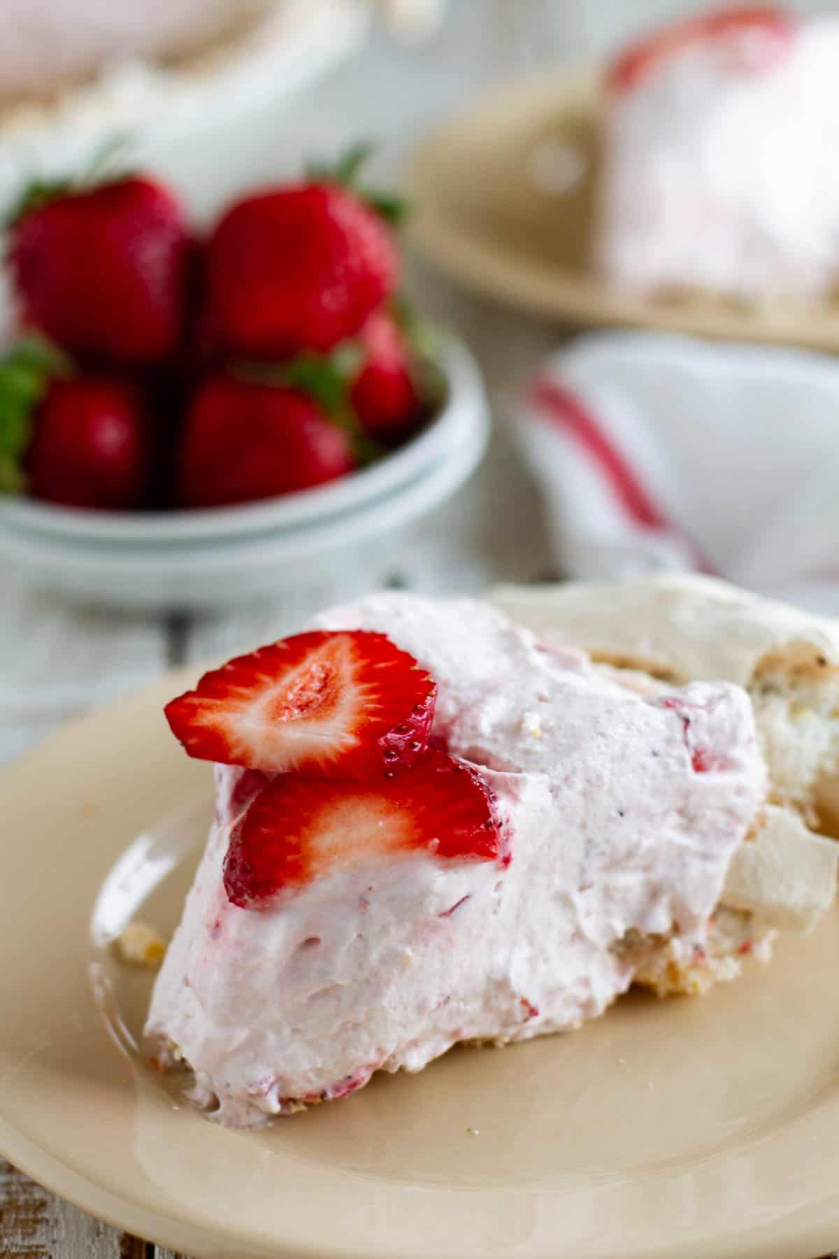 Slice of strawberry cream angel pie on a plate.