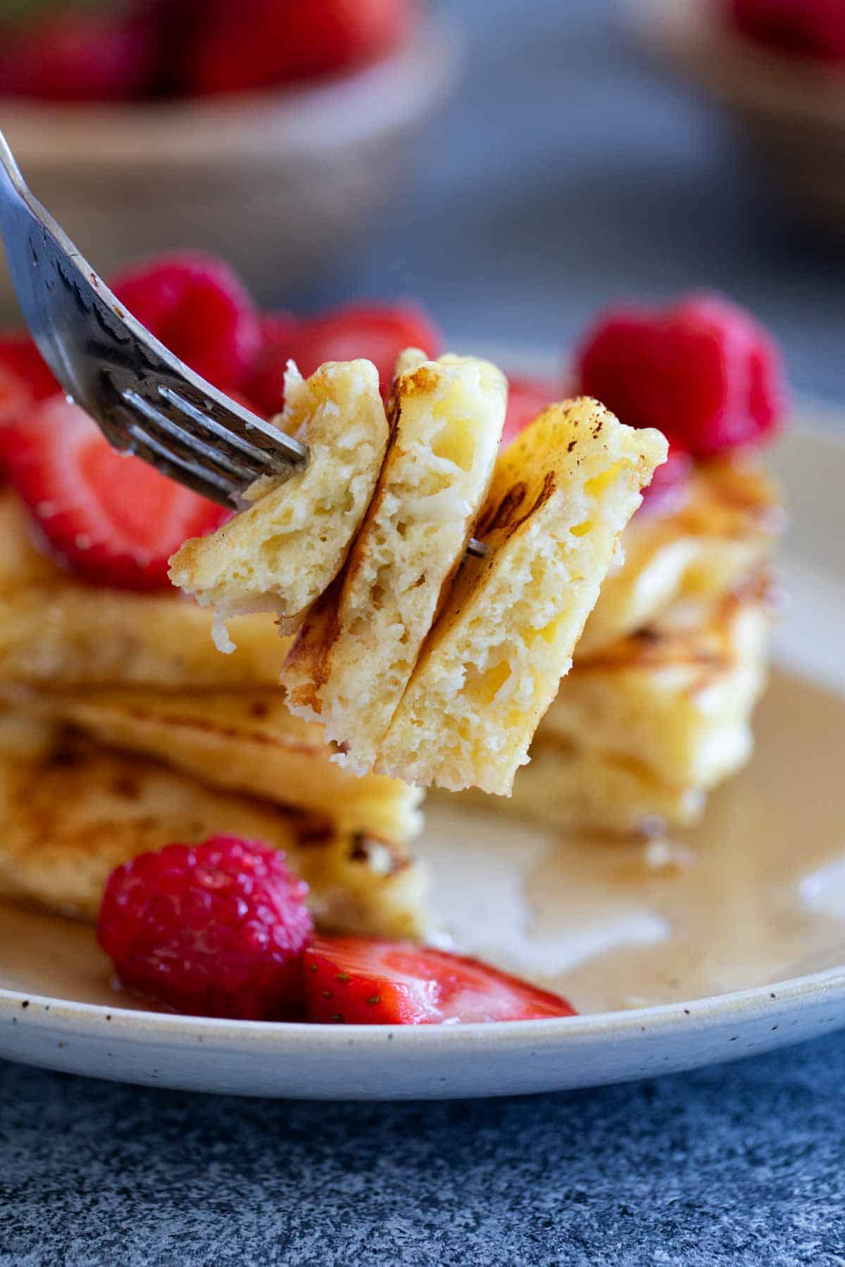 Fork with bite of cottage cheese pancakes on it.