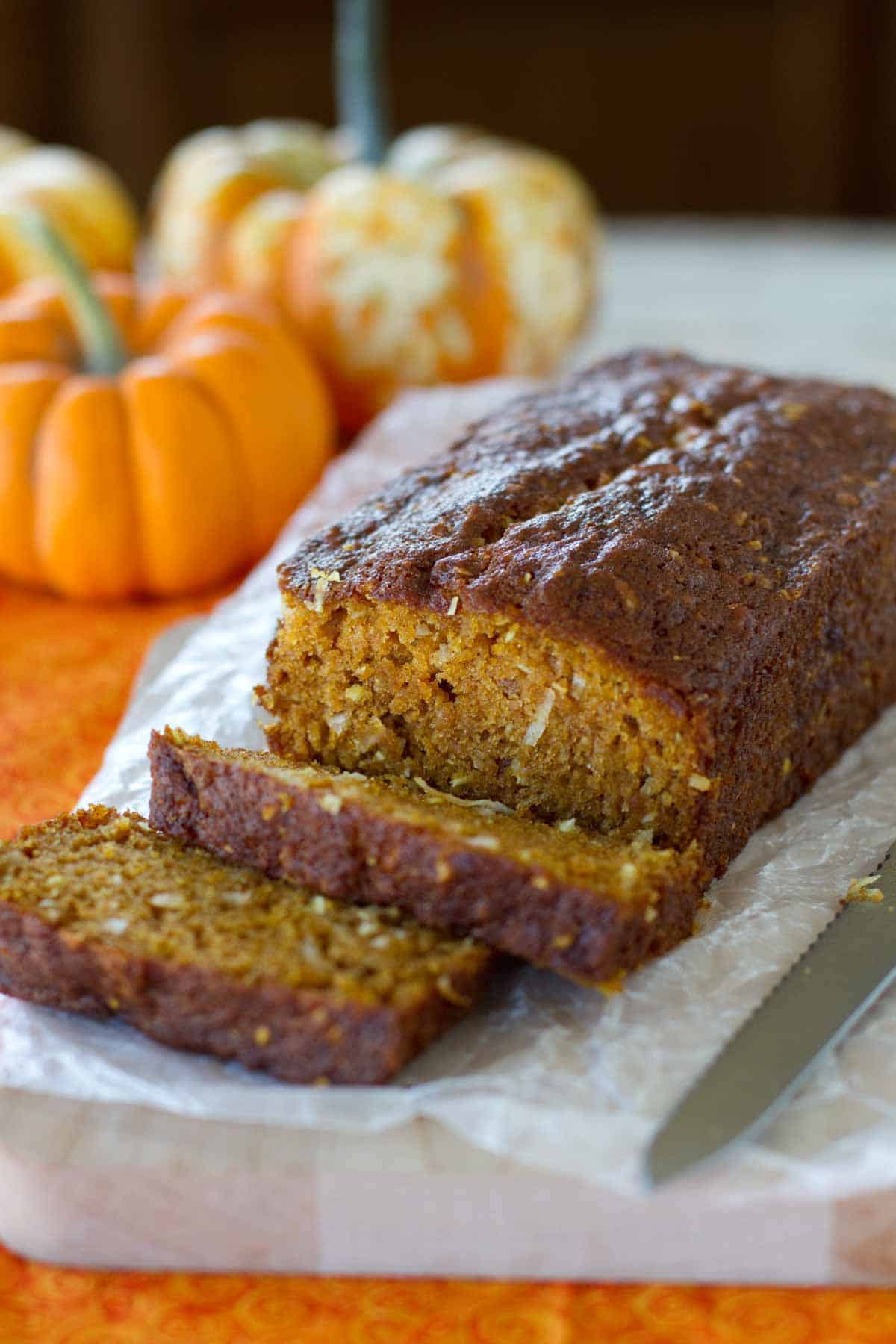 Loaf of pumpkin coconut bread with a few slices cut from it.