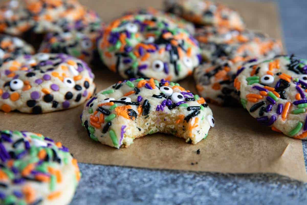 Halloween cookies with sprinkles with a bite taken from one of them.