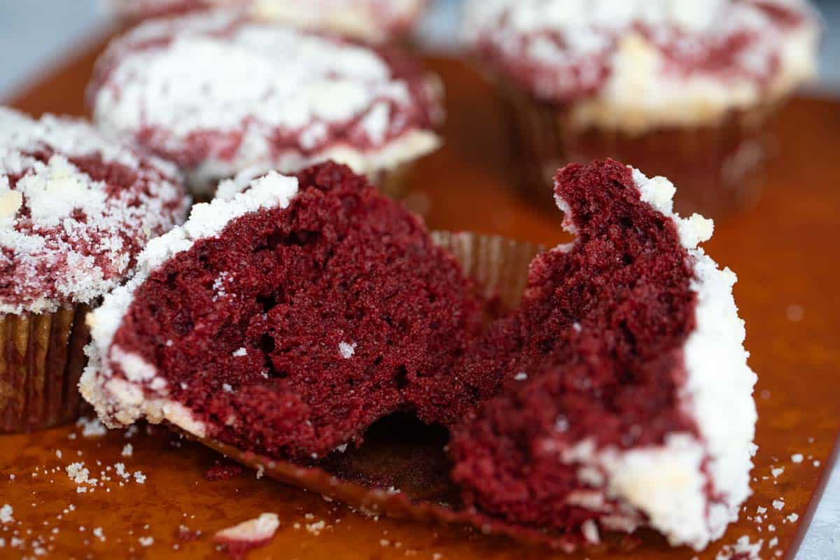 Red velvet muffin torn in half to show texture on the inside of the muffin.