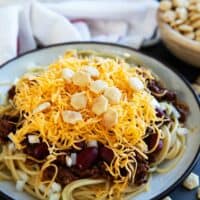 Plate filled with Cincinnati Chili served 5 way with cheese, onions, and kidney beans.