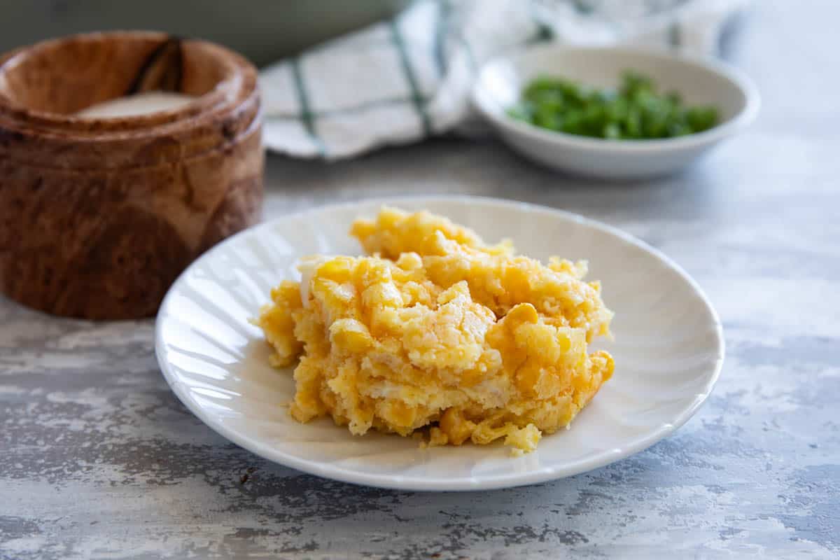 Serving of corn casserole on a small white plate.