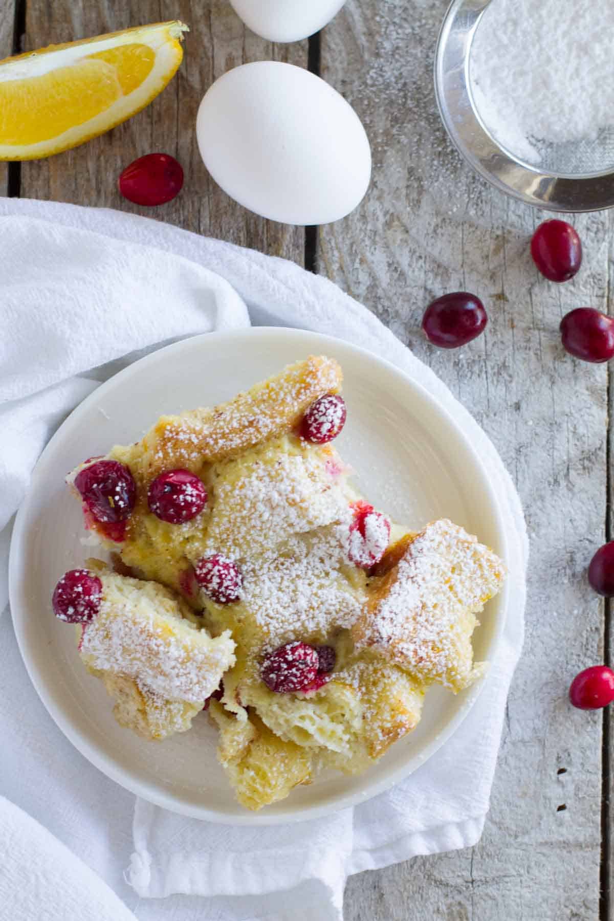 Serving of Cranberry Orange Baked French Toast Casserole on a small white plate.