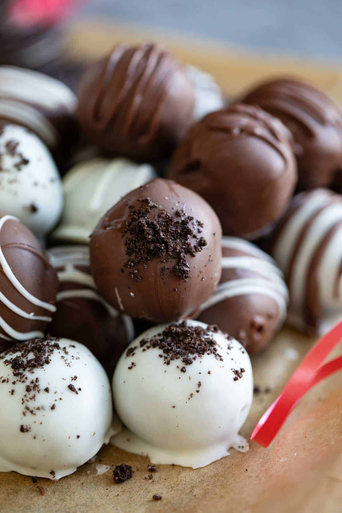 Oreo Balls in milk chocolate and white chocolate stacked on top of each other.