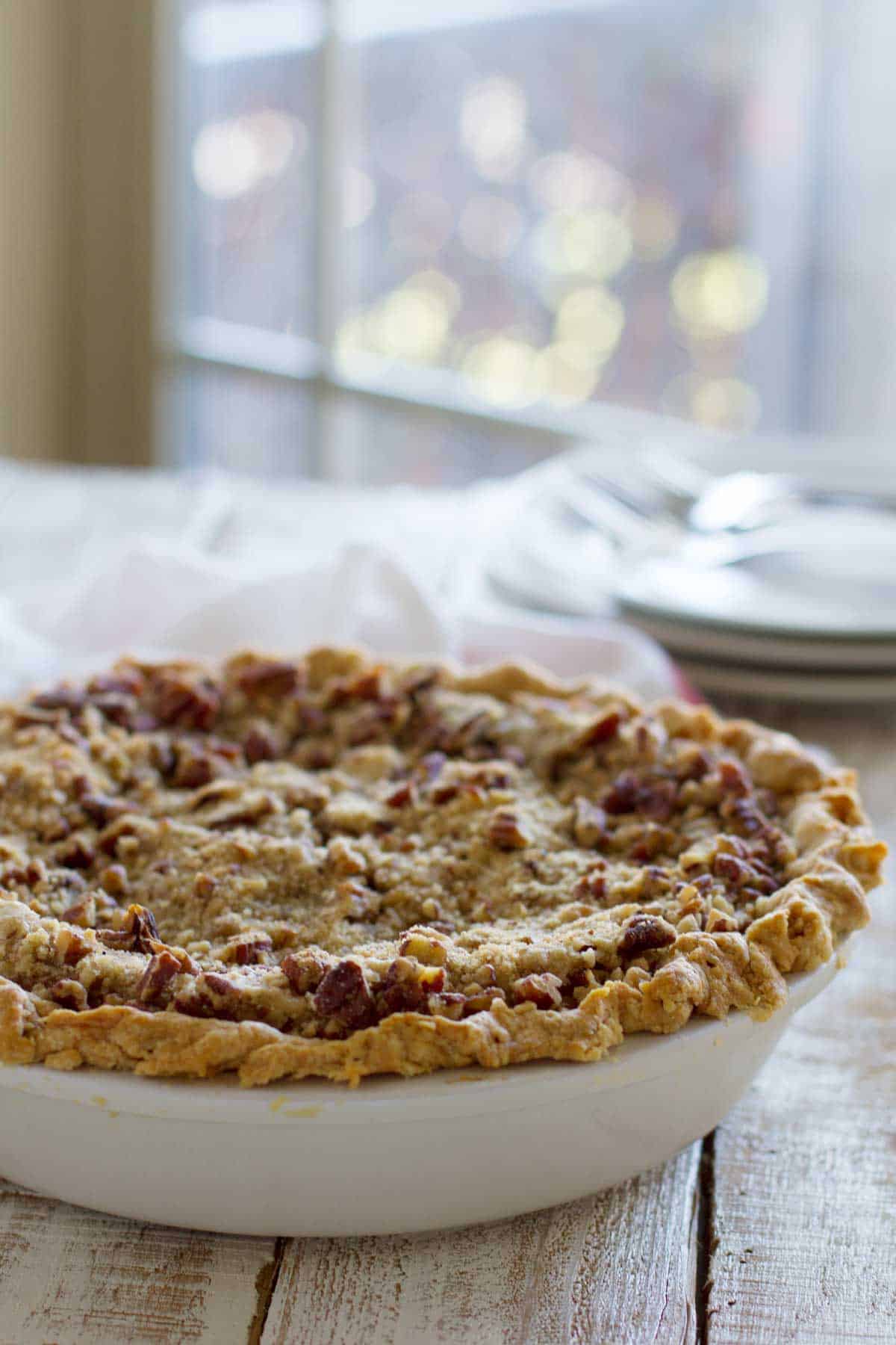 Full pumpkin cheesecake pie topped with a pecan crumble topping.