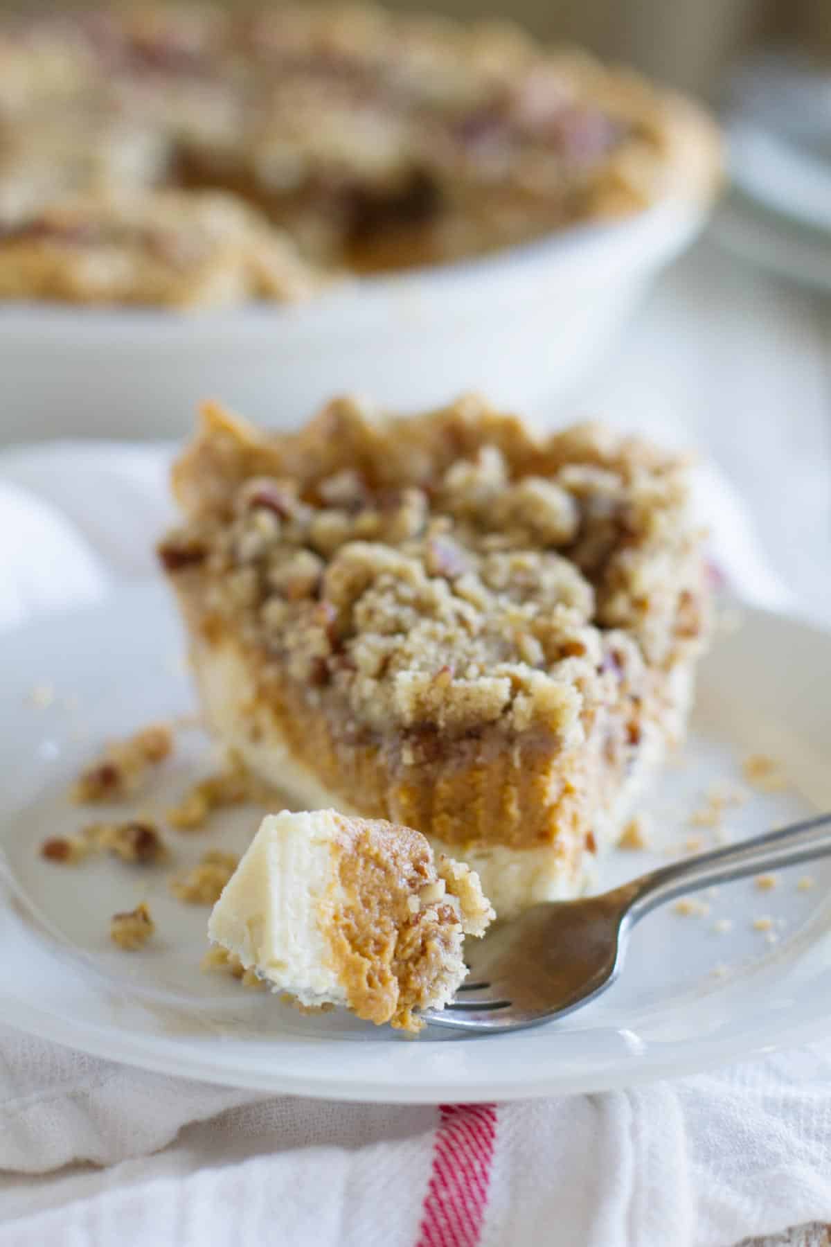 Slice of pumpkin cheesecake pie with a bite on a fork.