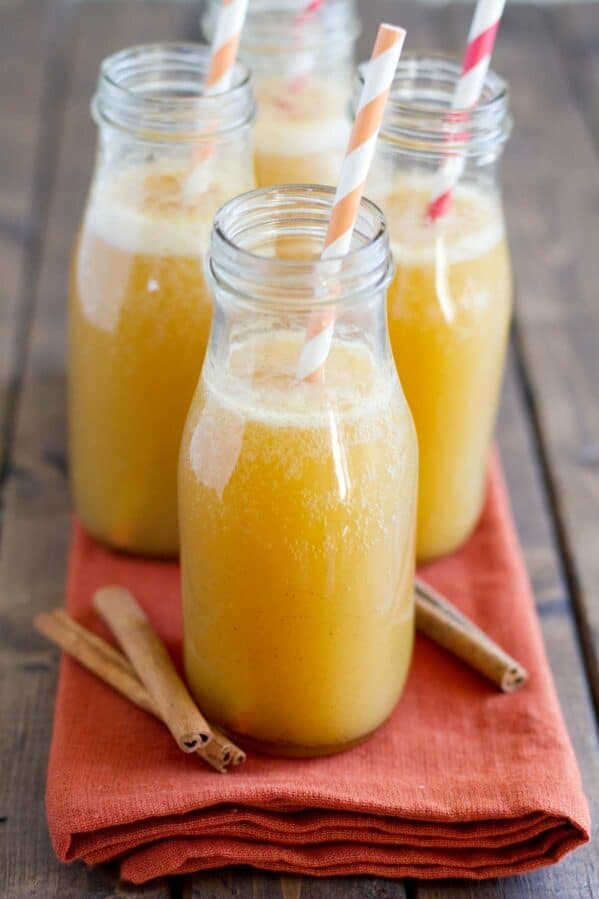 Glasses filled with Apple Cider Punch, with cinnamon sticks on the side.