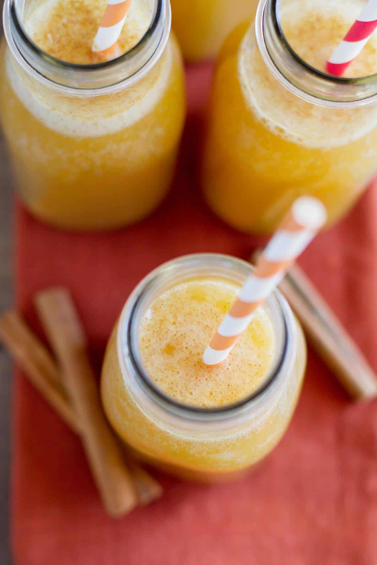 Glasses filled with apple cider punch and straws.