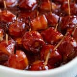 Bacon Wrapped Water Chestnuts covered in a homemade bbq sauce in a baking dish.