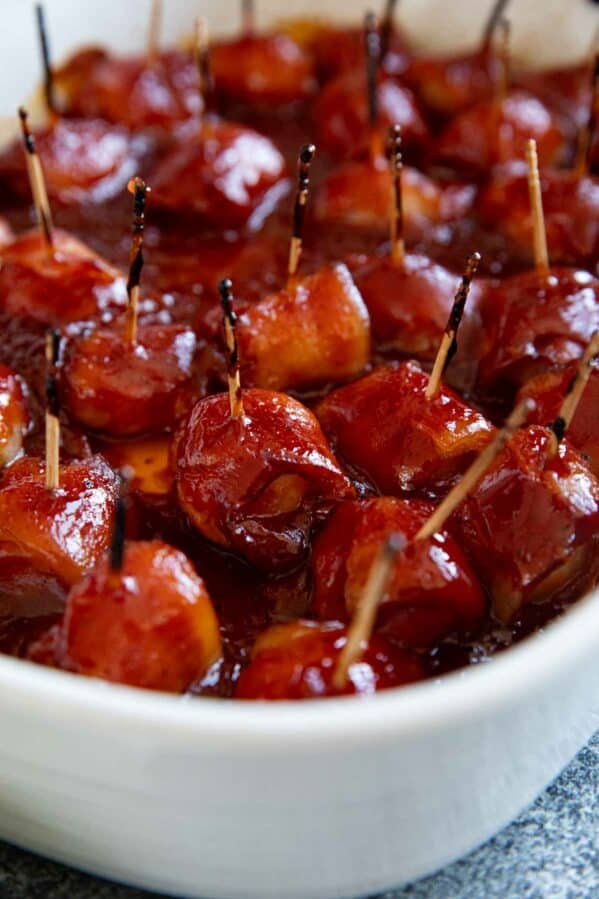 Bacon Wrapped Water Chestnuts covered in a homemade bbq sauce in a baking dish.