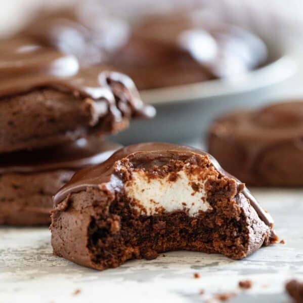 Chocolate marshmallow cookie with a bite taken out to show marshmallow in the center.