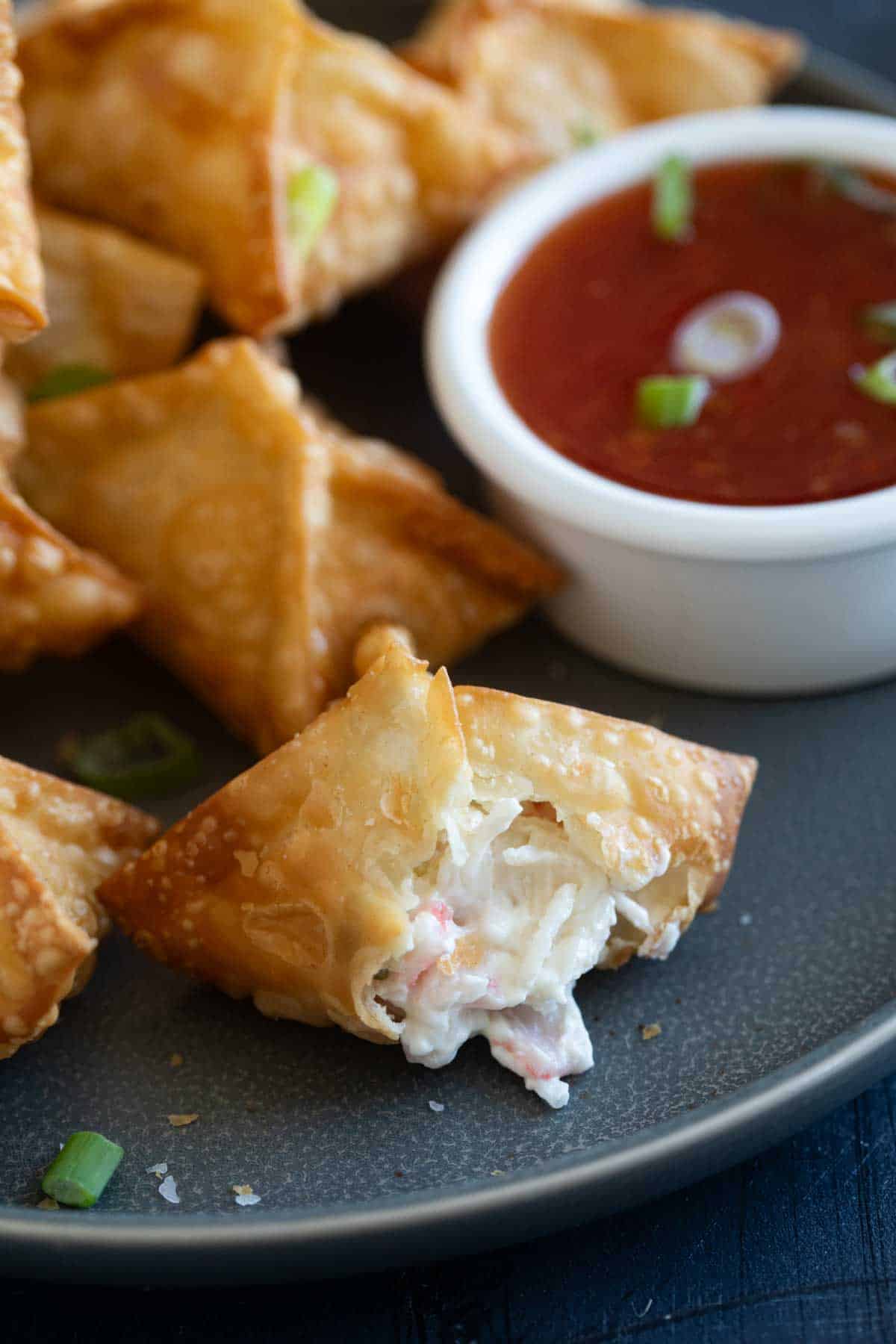 Crab Rangoon with a bite taken from one.
