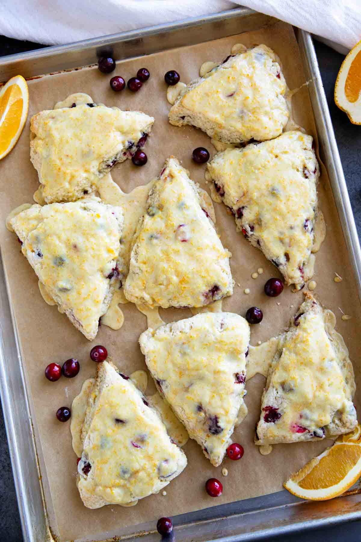 Cranberry orange scones made with fresh cranberries on a baking sheet.