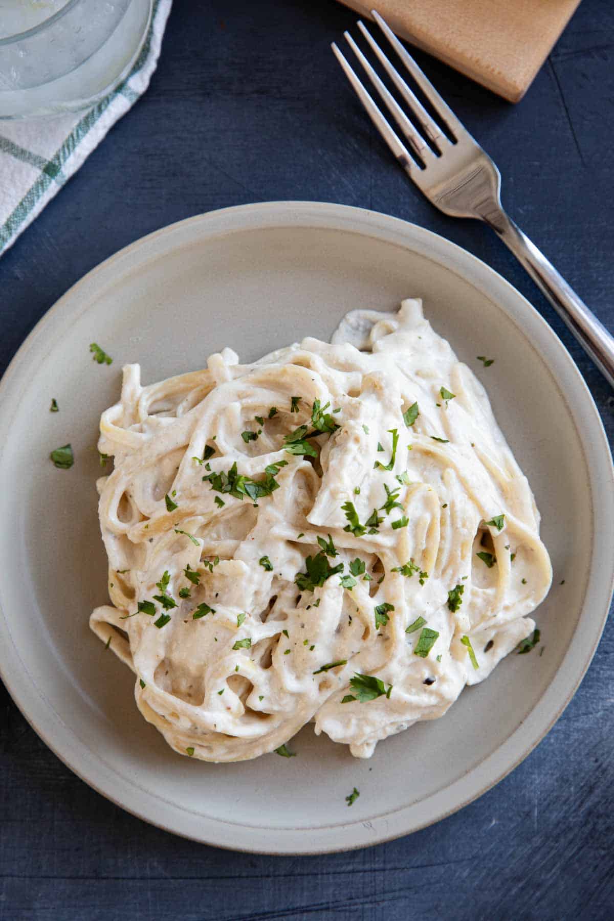 Slow cooker chicken alfredo with fettuccine noodles on a plate.