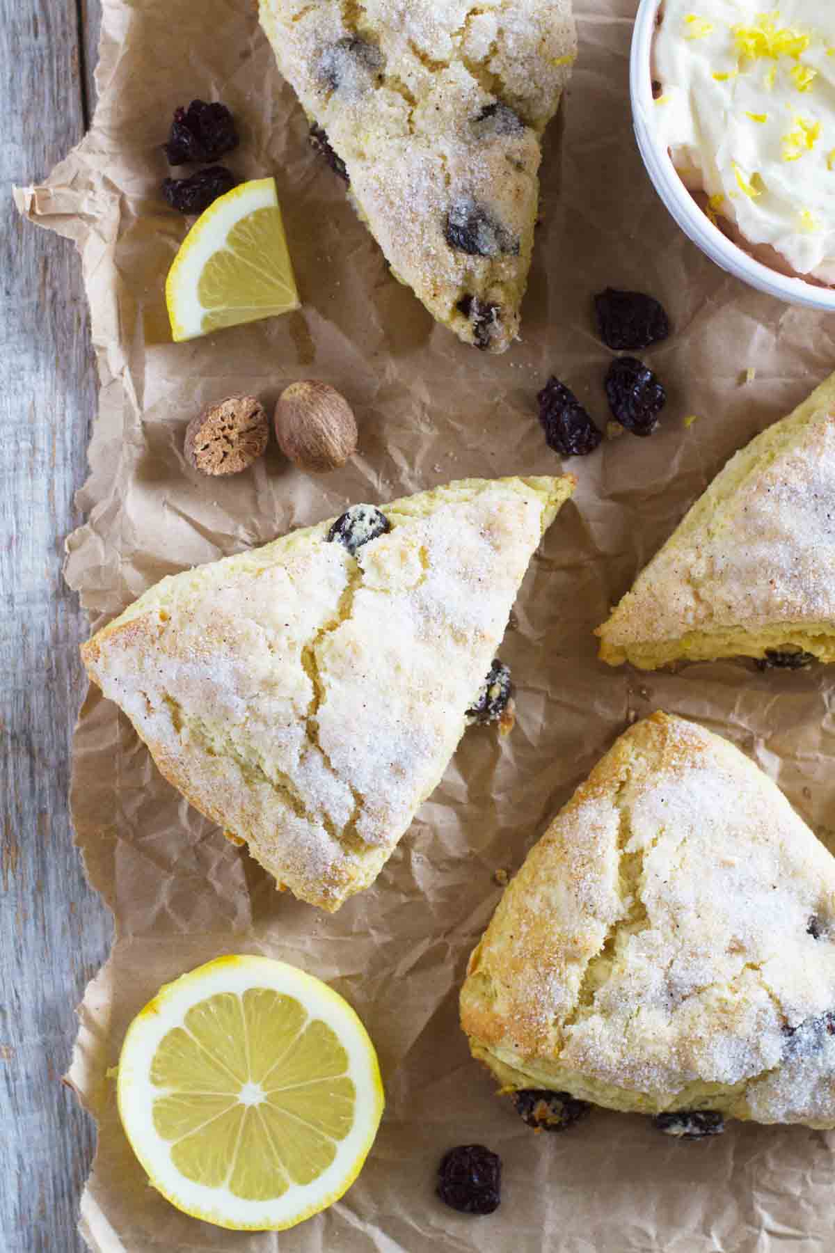 Lemon Scones with Nutmeg and Cherries on brown paper with lemon slices and cherries around.