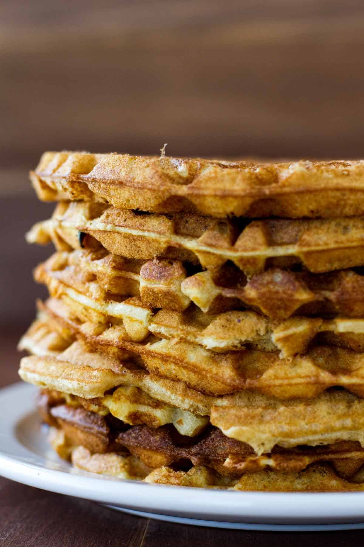 Stack of maple bacon waffles on a plate.