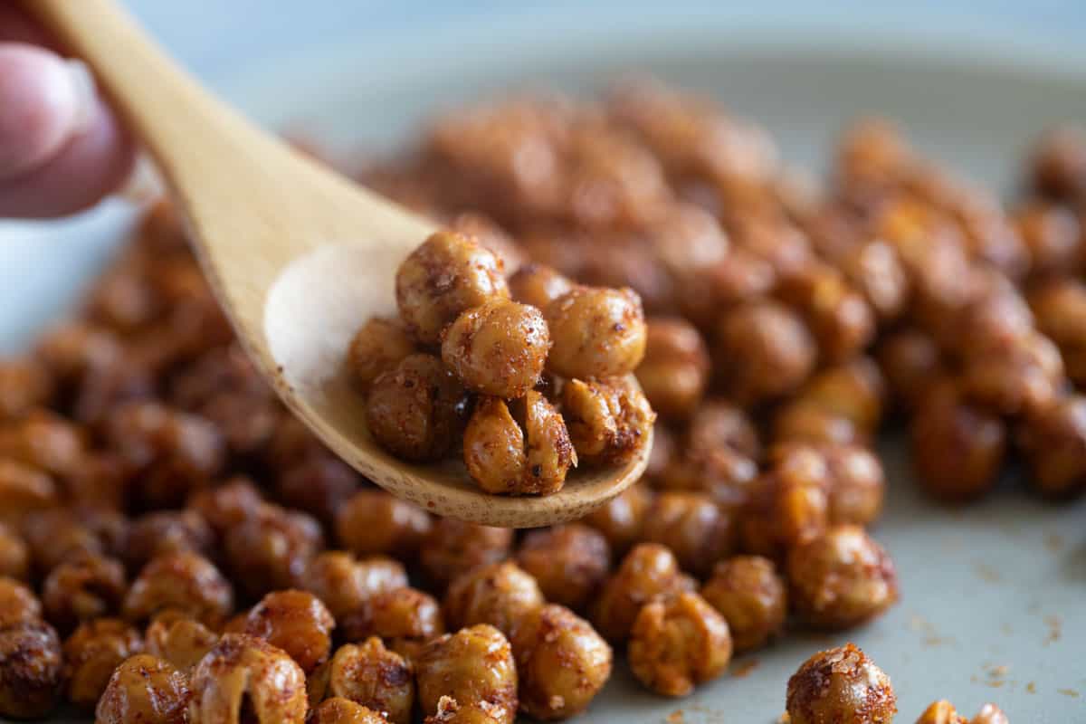 Spiced, roasted chickpeas in a wooden spoon.