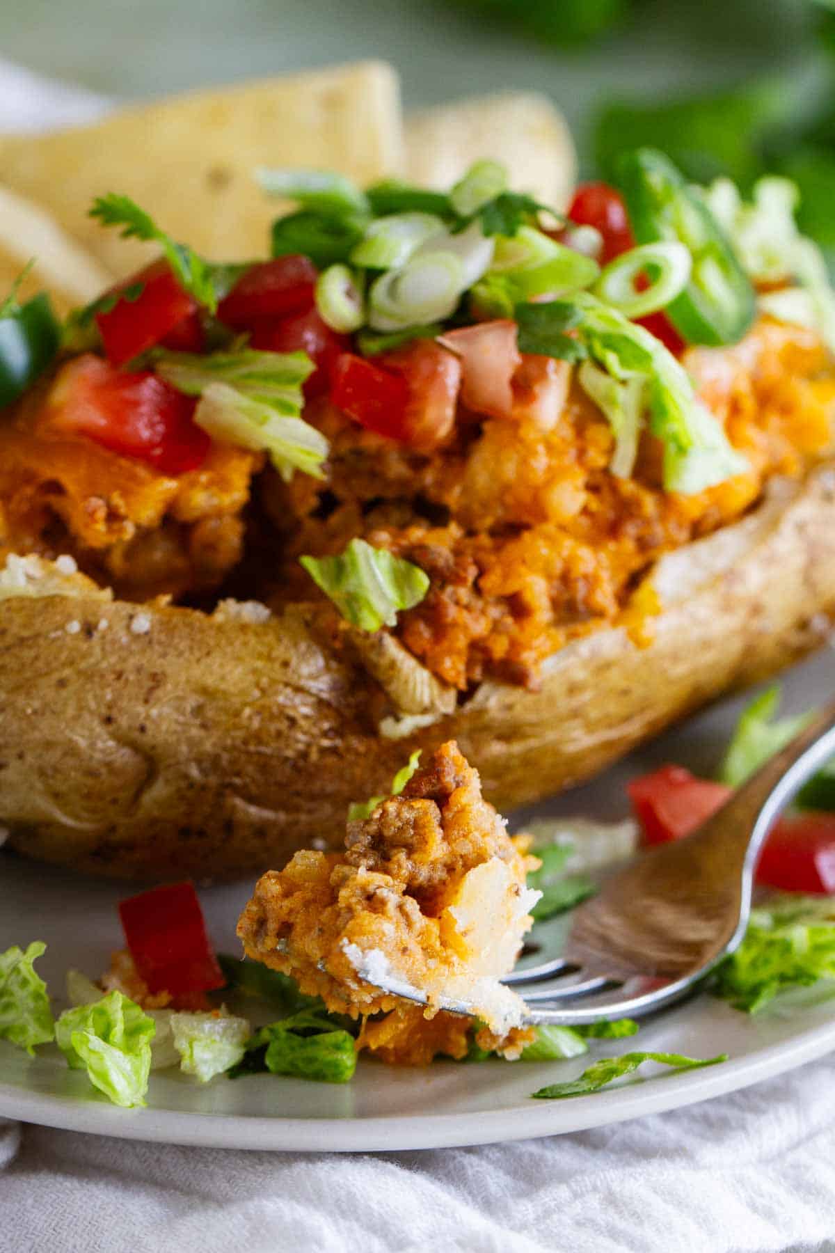 Taco stuffed potato with a bite taken from it.